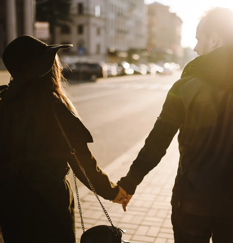 photo d'un couple marchant dans la rue, main dans la main